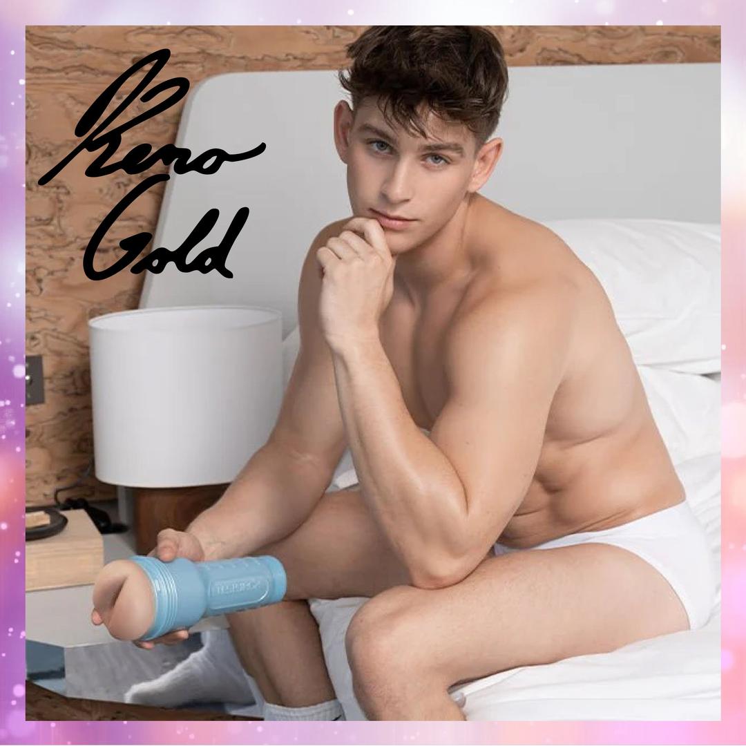 A young man in white underwear sits on a bed, holding a Fleshlight Fleshjack Boys Reno Gold: Realistic Male Masturbator Cake Butt, and looks at the camera. A large "Reno Gold" autograph appears in the top left corner.