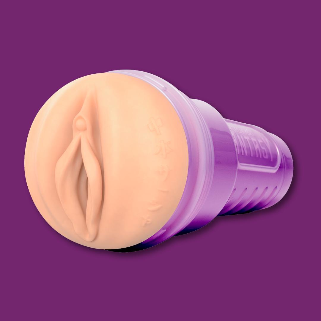 The Fleshlight Fantasy Sasha Nakamoto: Realistic Fantasy Male Masturbator by Fleshlight features a design resembling female anatomy in a translucent purple case, shown against a solid purple background.