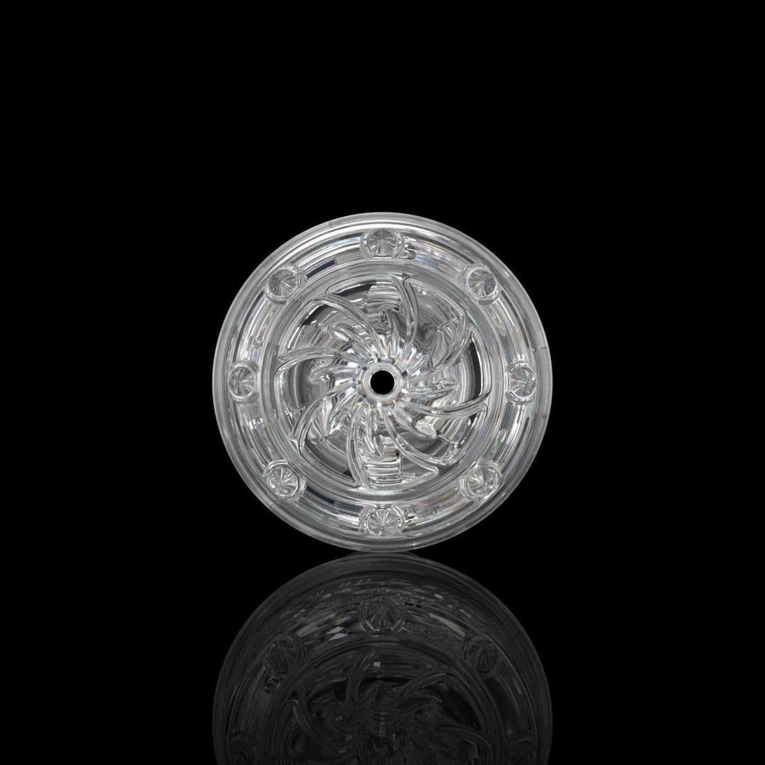 A clear, intricately patterned glass disc with a central hole evokes the swirling textures of the Fleshlight GO Torque Portable Stroker by Fleshlight, displayed upright against a black background with a subtle reflection beneath.