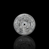 A clear, intricately patterned glass disc with a central hole evokes the swirling textures of the Fleshlight GO Torque Portable Stroker by Fleshlight, displayed upright against a black background with a subtle reflection beneath.