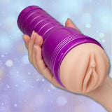 A hand holds the Fleshlight Fantasy Sasha Nakamoto: Realistic Fantasy Male Masturbator by Fleshlight, showing its anime-inspired purple sleeve with tentacle texture against a softly blurred blue and white background.