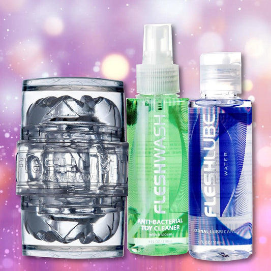 The Fleshlight Quickshot Vantage Value Pack by Fleshlight—featuring a clear masturbation sleeve, blue lube, and green toy cleaner—is the ultimate starter kit, shown together against a purple bokeh background. 1080