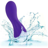 The CalExotics Flex Bend & Hold Rumbler G-Spot Stimulator, a curved purple silicone toy, splashes into clear water, sending dynamic droplets and waves across a white background.
