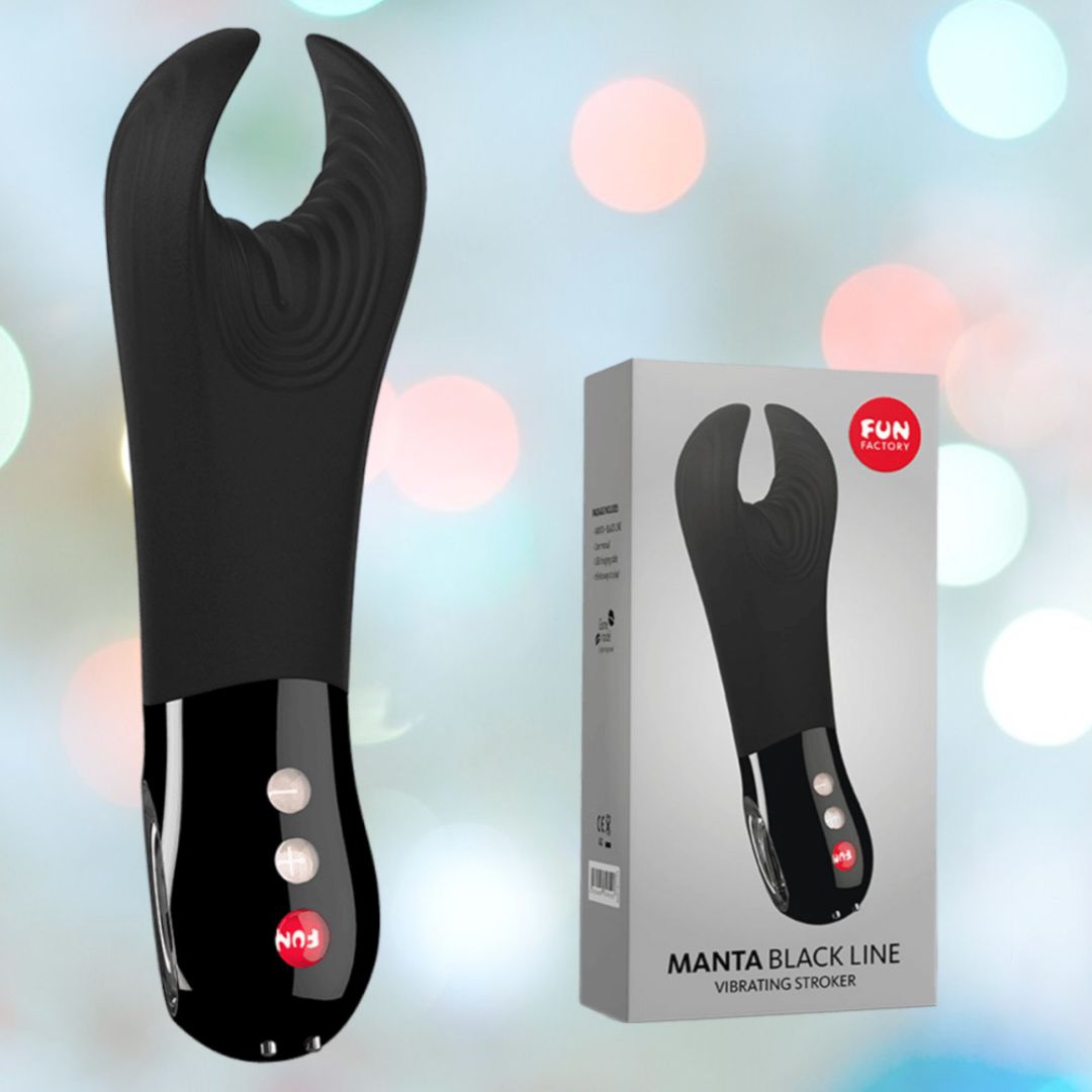 The Fun Factory Manta Rechargeable Vibrating Male Stroker for Men in black is displayed next to its packaging, featuring prominent red branding and a clear product image. This elegant and ergonomic penis vibrator combines sophistication with pleasure, set against a backdrop of soft, blurred pastel colors that heighten its allure.