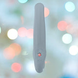 The Fun Factory Share Vibe Pro Cool - Grey, a modern and sleek handheld device featuring a single button and textured grip, stands against a blurred background of colorful lights, promising strong vibrations for mutual pleasure.