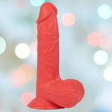 The Get Lucky Mr. Ruby 7.5" Realistic Dildo with Suction Cup, in a striking red silicone, stands upright against a softly blurred backdrop filled with circular bokeh lights in pastel hues. The dildo's textured surface enhances its realistic design.