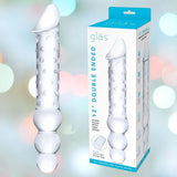 A Gläs 12" Double Ended Glass Dildo with Anal Beads, featuring a smooth design on one end and textured for temperature play on the other, is pictured next to packaging adorned with the brand name "Gläs" that highlights the product's enticing features.