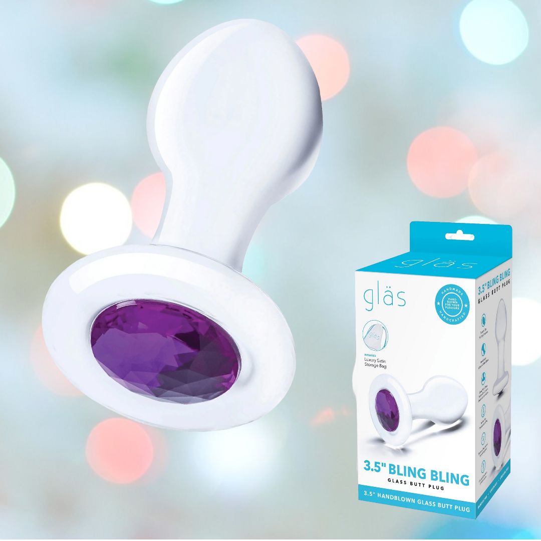 In front of a softly blurred background, the Gläs 3.5" "Bling Bling" Glass Butt Plug is showcased, featuring a hypoallergenic white glass design with a purple gem at its base. Next to it, the product packaging highlights the same item, emphasizing its suitability for prostate play with the words "3.5” Bling Bling.