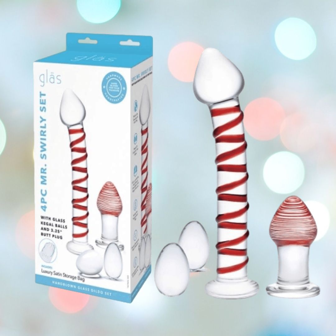 Against a bokeh-lit backdrop, the Gläs 4pcs Mr. Swirly Set is showcased, featuring a Mr. Swirly Glass Dildo with a red spiral, two round kegel balls, and an elegant butt plug. The packaging highlights these exquisite items with detailed descriptions.