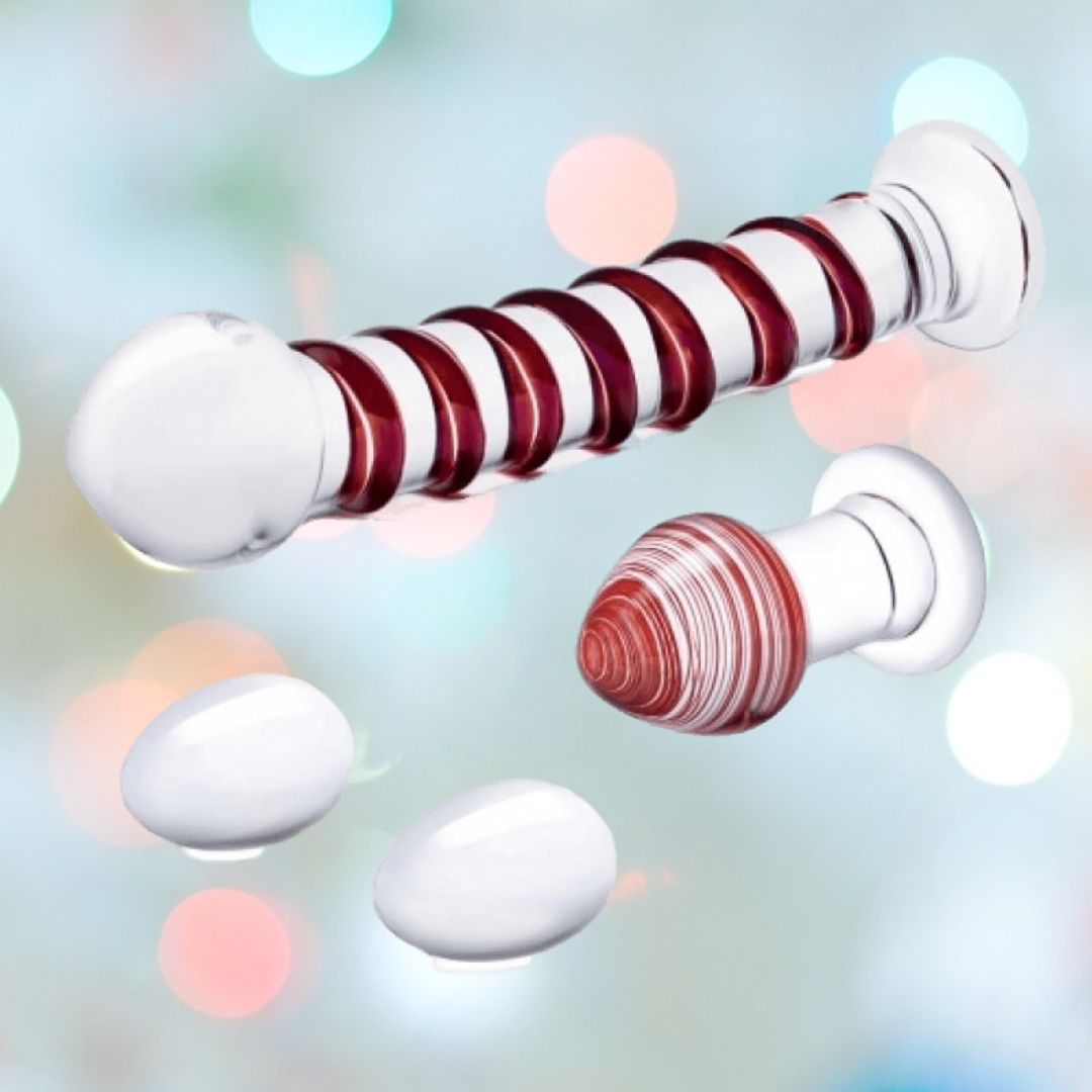 Introducing the Gläs Mr. Swirly Set: a striking white and red swirled mushroom toy paired with a matching cylindrical object, accented by sleek white ovoid shapes set against a vibrant kaleidoscope of lights and colors.