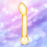The Gläs Honey Dripper 7" Double Ended Anal Dildo by Gläs stands upright against a soft pastel background with pink and purple hues and glowing bokeh effects.