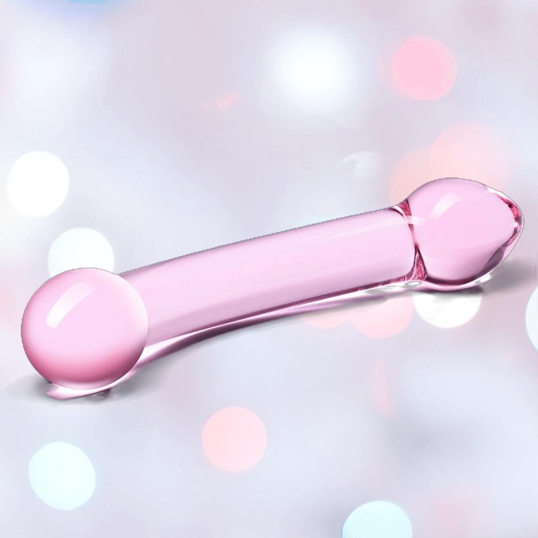 The Gläs Double Trouble Luxury Dual-Head Glass Dildo by Gläs, in purple, features rounded bulbs on both ends and is showcased against a soft pastel bokeh background.