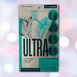 A package of Glyde Ultra Super-Thin Condoms by Glyde appears against a softly blurred backdrop with white and pink lights. The beige and teal box showcases "ULTRA" text and botanical graphics, emphasizing these vegan, ultra-thin condoms.