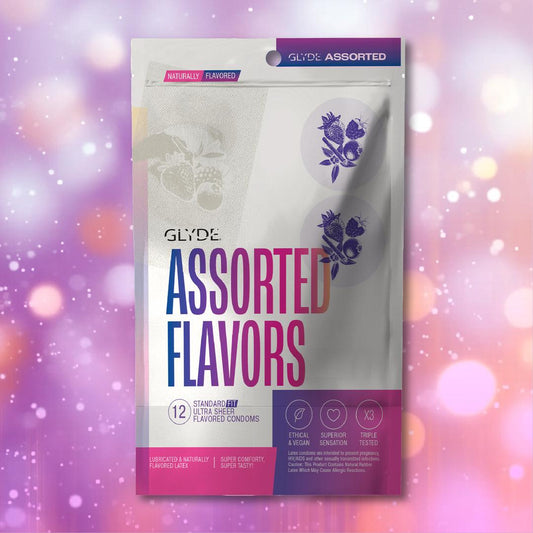 A box of Glyde Natural Flavors Condoms with 5 Flavors (12-Pack) is shown against a pink and purple bokeh background. The packaging notes they are vegan, made from natural latex, ethically produced, and triple-tested for quality. 1080