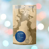 A package of Glyde Maxi LARGE Size Vegan Condoms by Glyde, featuring an abstract image of two people kissing. The bag contains 36 ultra-thin, natural rubber latex condoms set against a blurred, colorful background.