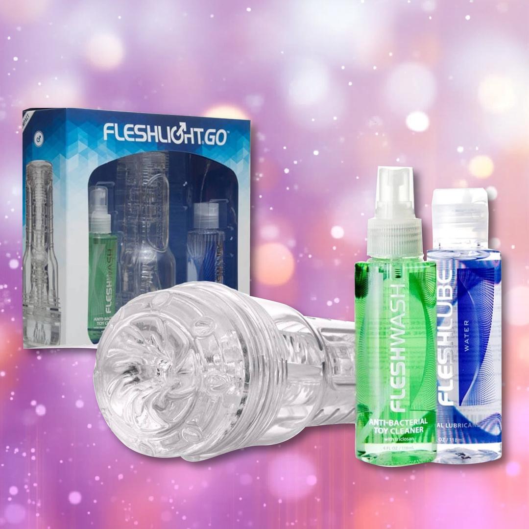 The Fleshlight GO Torque Portable Stroker Value Pack by Fleshlight, featuring a compact male masturbator, water-based lube, and toy cleaner, is displayed with its box against a pink-purple bokeh background.
