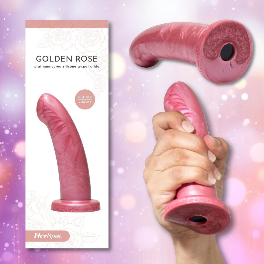 A hand holds the Fleshlight HerSpot Golden Rose Dildo by Fleshlight, a pink, curved platinum-cured silicone toy with floral patterns. Shown close-up and in packaging labeled "Fleshlight HerSpot Golden Rose Dildo" and "Medium 6 Inches.