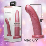 A Fleshlight HerSpot Golden Rose Dildo made of platinum-cured silicone stands upright by its packaging, showing the 6-inch medium size and Fleshlight branding. A soft, blurred pink background adds an elegant touch.