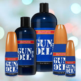 An image showcasing five blue bottles of hypoallergenic GUN OIL 'H2O' Water-Based Lubricant by Gun Oil, each adorned with orange caps. The bottles, which range in size from 4 oz to 32 oz, feature labels in red and blue with white text. The background is enhanced by soft, colorful bokeh lights.