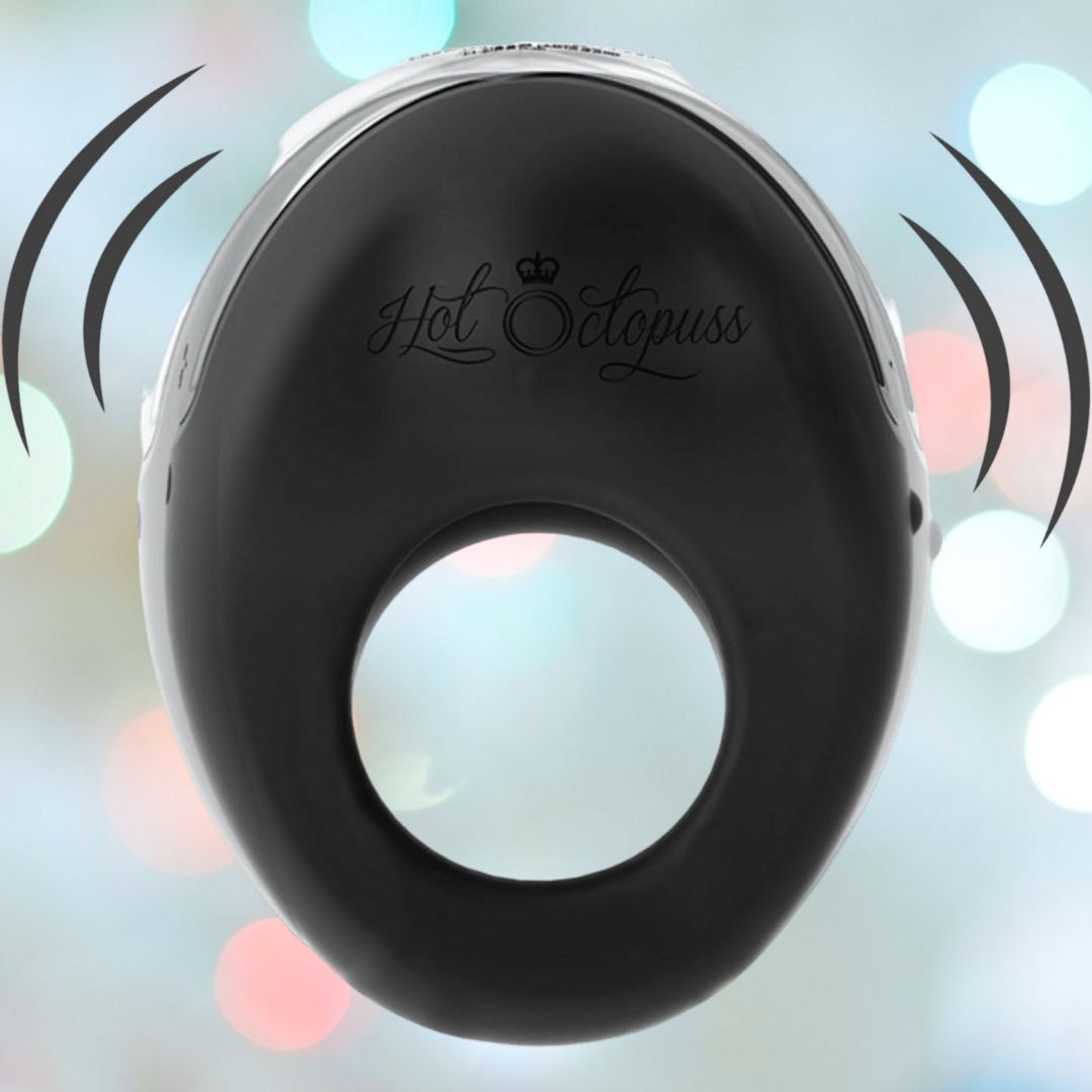 The Hot Octopuss Atom - Vibrating Cock Ring, featuring the brand name "Hot Octopuss," is designed to deliver intense partner stimulation, depicted with stylized vibration lines. The background showcases a soft bokeh effect in pastel shades.