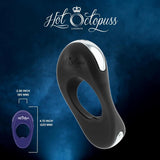 Against a blue smoky background, the Hot Octopuss Atom Plus - Vibrating Cock Ring, in sleek black with an oval shape, loop, and silver button is prominently displayed. Text reads "Hot Octopuss London." An inset highlights the measurements: 4.72 inches (120 mm) and 2.36 inches (60 mm). Experience powerful vibrations for unparalleled perineum stimulation.