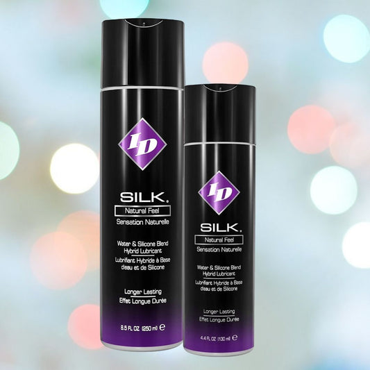 Two black bottles with purple diamond-shaped logos labeled "ID Silk Long-Lasting Hybrid Lubricant" by ID Lubricants are displayed against a blurred background. The larger, 8.5 fl. oz. bottle and the smaller, 4.4 fl. oz., feature a long-lasting formula for an enhanced experience. 1080