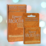 Two packages of Kimono MicroThin Ribbed + Sensi-Dots Condoms are displayed, showcasing them as "America's Thinnest Textured Condom" made from premium natural latex. The packaging emphasizes being "5X Tested" for reliability. A soft gradient with blurred lights in the background enhances their allure.