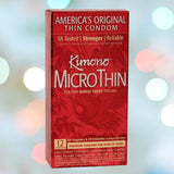 A red box of Kimono MicroThin Condoms is showcased against a blurred background featuring soft, circular lights. The text promotes it as "America's Original Thin Condom," underscoring its reliability, strength, and the "barely there" sensation. Each box contains 12 premium latex condoms.