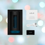 The LELO F1S V3 XL Male Masturbator Blue is displayed next to its packaged items: a USB cable, a warranty registration card, and an information card. Featuring dual motors and app-connected functionalities, it is set against a background of soft, vibrant bokeh lights.