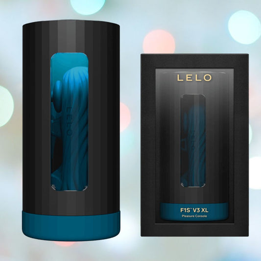 The black and teal cylindrical device, featuring dual motors, highlights a transparent vertical window next to its elegant black box labeled "LELO F1S V3 XL Male Masturbator Blue." This app-connected product by LELO is set against a backdrop of blurred, colorful lights. 1080