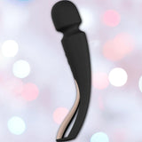 The LELO Smart Wand 2 Medium Personal Wand Massager by LELO, shown in sleek black with a curved design and rounded head, is waterproof and built for comfort and versatile use. The product is displayed against soft pink and white blurred lights.