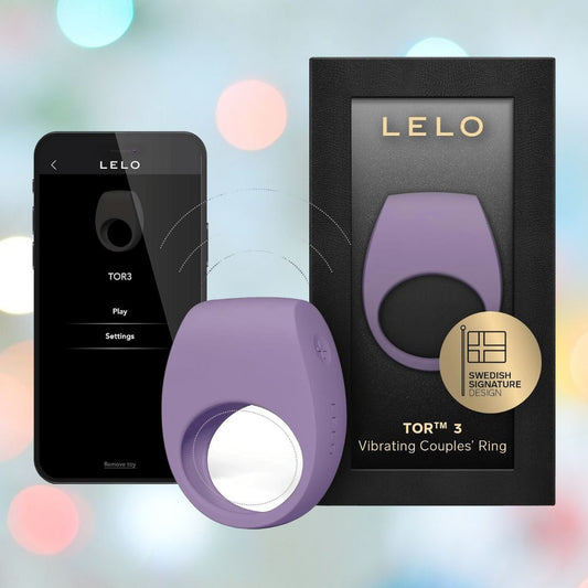 The LELO Tor 3 - Violet Dusk vibrating couples' ring is pictured beside its black packaging and a smartphone showing its app controls, set against a vibrant, blurred background. 1080