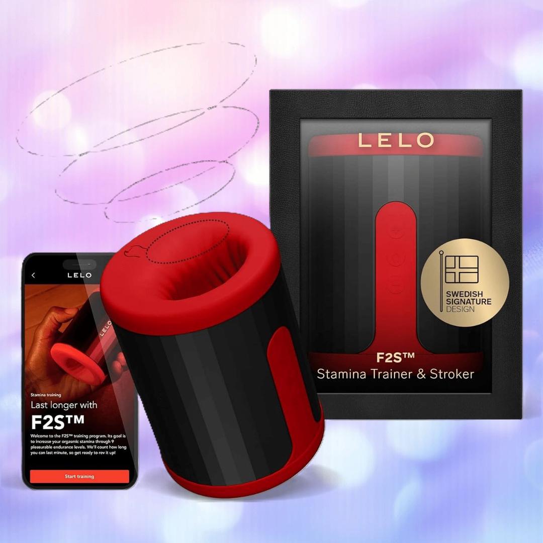 The LELO F2S Massager & Stroker Red by LELO is displayed with its packaging and a smartphone featuring the app interface, all set against a soft, colorful background.