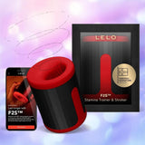 The LELO F2S Massager & Stroker Red by LELO is displayed with its packaging and a smartphone featuring the app interface, all set against a soft, colorful background.