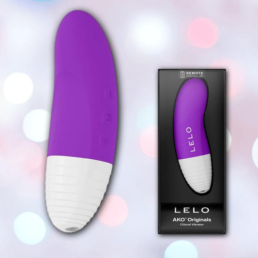 A LELO AKO Originals Purple waterproof vibrator is displayed beside its branded packaging, both set against a soft, pastel bokeh background. 1080