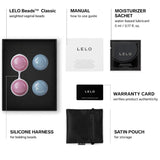 The LELO Luna Beads: Pelvic Floor Training Kegel Balls by Lelo come with two pink and two blue weighted beads, a black silicone harness, manual, moisturizer sachet, warranty card, and satin pouch—perfect for pelvic floor wellness.