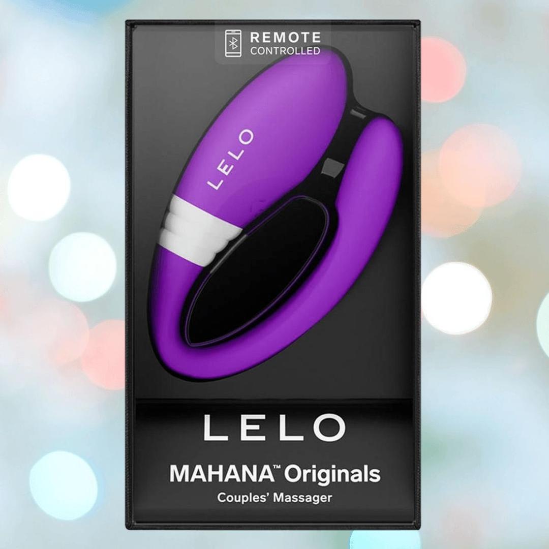A boxed LELO Lelo MAHANA Originals Purple couples' massager, remote controlled, is displayed against a blurred pastel background.