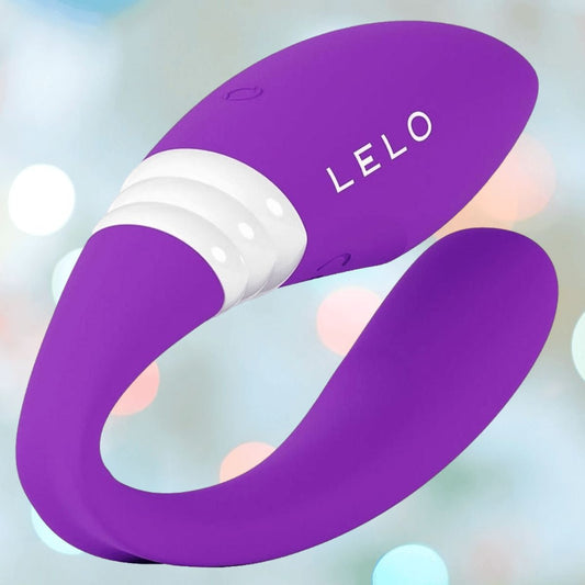 The LELO MAHANA Originals Purple is a curved silicone wearable vibrator with a smooth finish and white accent, shown against a soft, pastel-lit background. 1200