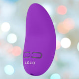 The LELO NEA Originals Purple personal massager features two black control buttons, displayed against a soft, pastel bokeh background.