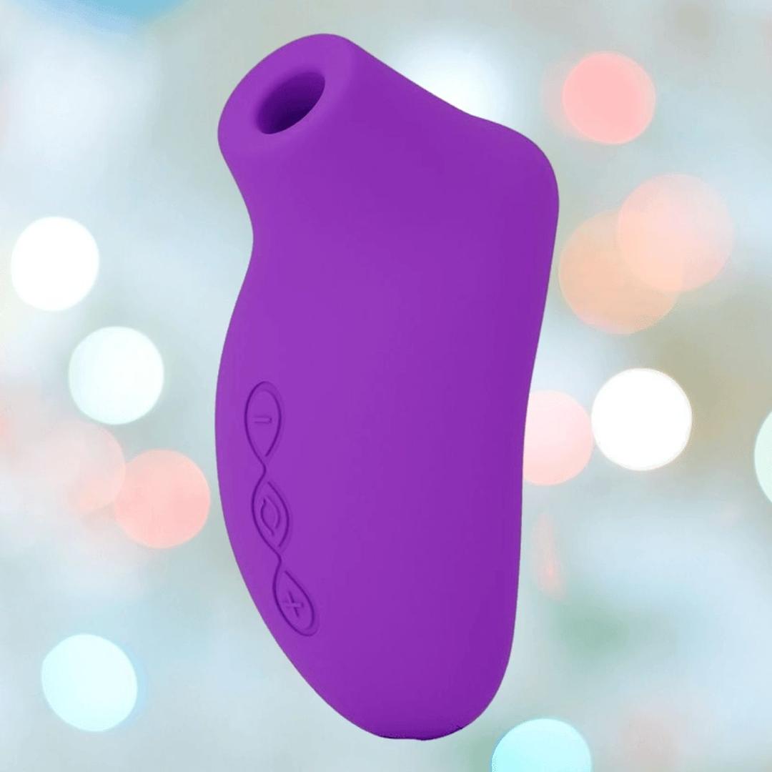 The LELO SONA Originals Purple is a silicone handheld device with three side control buttons, shown against a blurred background with circular pastel lights.