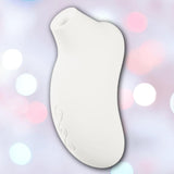 The LELO Sona 3 - Cream is a white, curved handheld device with an oval opening and SenSonic technology, shown against a soft background with pink, blue, and white bokeh lights.