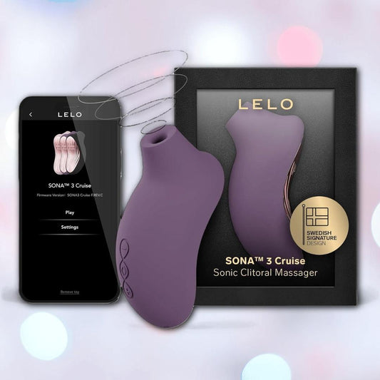 A LELO Sona 3 Cruise - Plum clitoral massager, crafted from body-safe silicone, is pictured beside its packaging and a smartphone showing sonic wave controls, set against a softly lit background with blurred light spots. 1080
