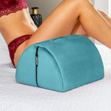 A person in red lingerie reclines on a bed, using the Liberator BonBon Microvelvet - Teal pillow by Liberator—a supportive sex toy mount with a zipper, perfect for hands-free solo play.