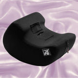 The Liberator Pulse MicroFiber - Black by Liberator is a curved foam cushion for clitoral stimulation, featuring a small white unicorn logo and shown on silky, light purple fabric.
