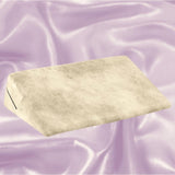 A Liberator Wedge Ibiza Collection - Natural sex pillow by Liberator sits on a sleek, lavender satin background.