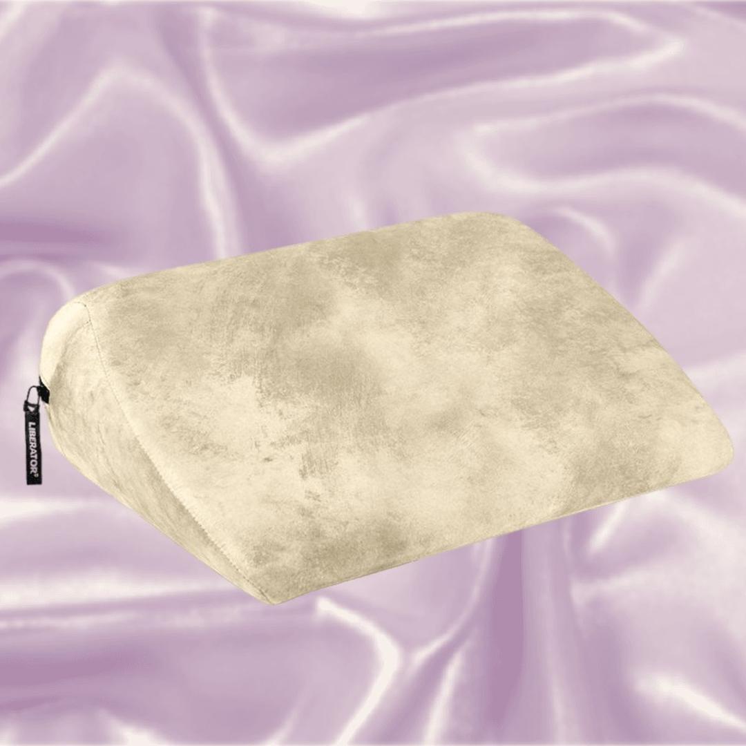 The Liberator Jaz Ibiza Collection - Natural, a beige wedge pillow by Liberator with a soft texture, rests on light purple satin—ideal for added comfort and G-spot stimulation.