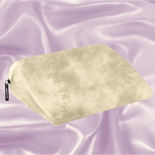 The Liberator Jaz Ibiza Collection - Natural, a beige wedge pillow by Liberator with a soft texture, rests on light purple satin—ideal for added comfort and G-spot stimulation. 1080