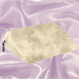 The Liberator Jaz Ibiza Collection - Natural, a beige wedge pillow by Liberator with a soft texture, rests on light purple satin—ideal for added comfort and G-spot stimulation.
