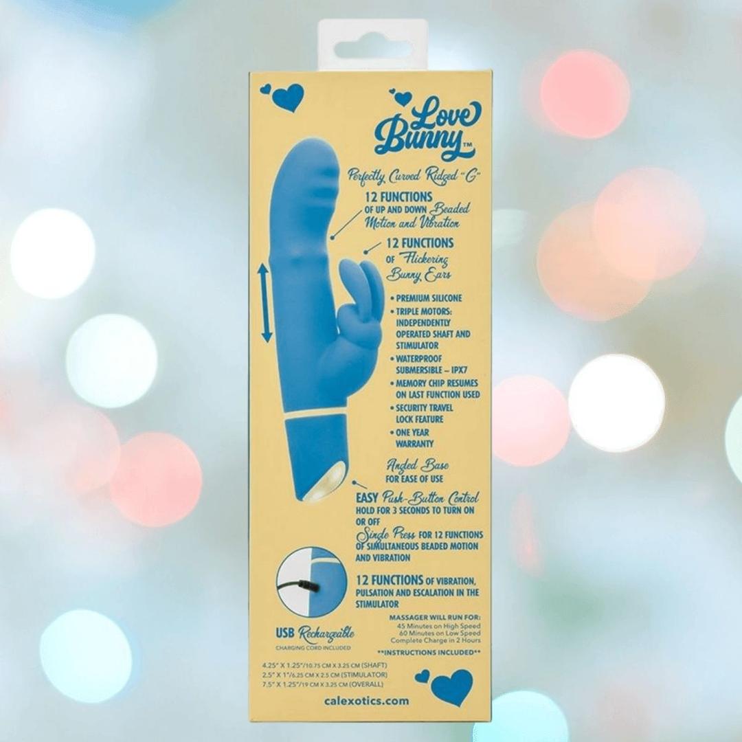 Packaging for the CalExotics Love Bunny Beaded “G” Bunny, showing product details on a yellow background with blue text and heart icons. The image features a blue silicone vibrator with a bunny-shaped clitoral stimulator.
