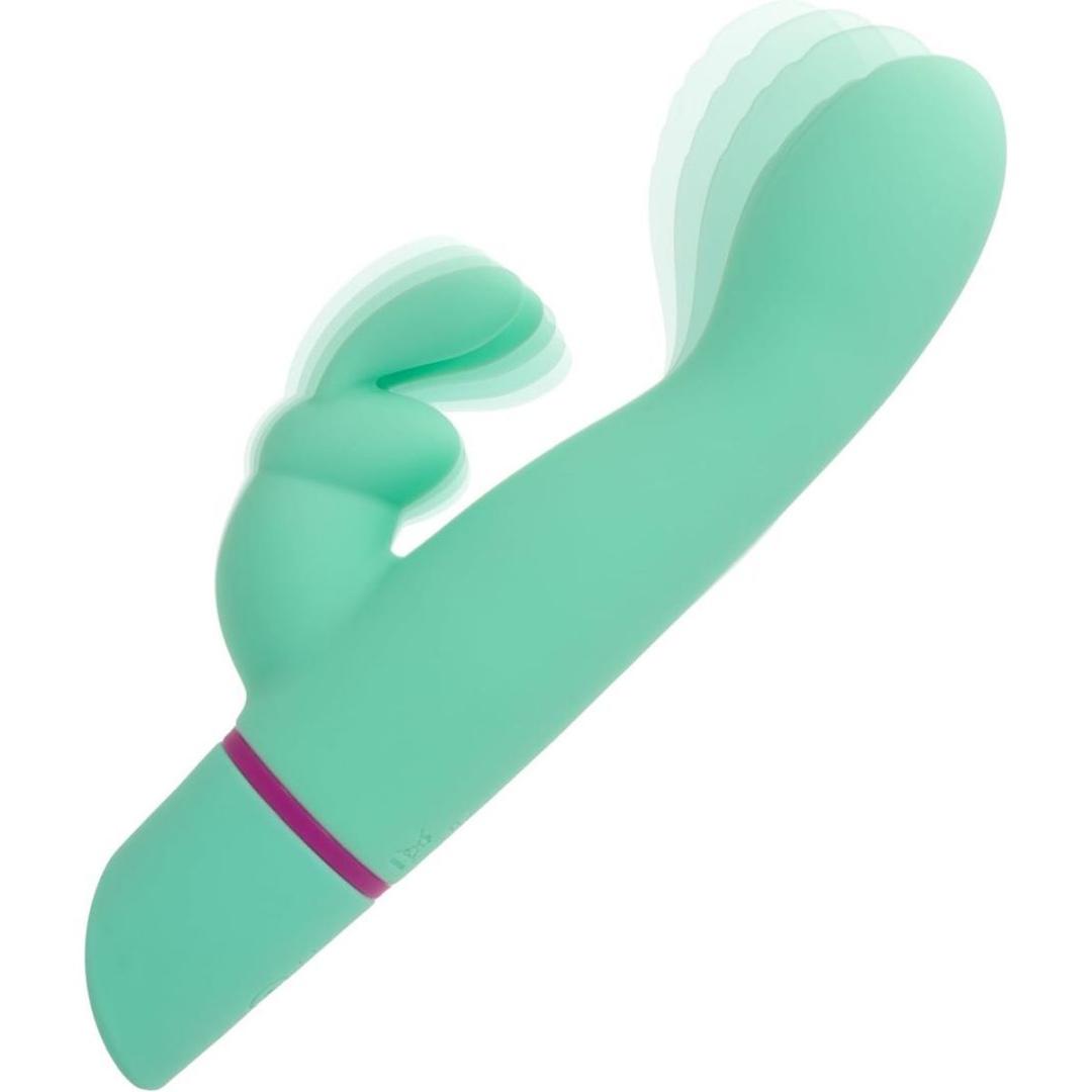 The CalExotics Love Bunny Rockin’ “G” Bunny is a teal, curved silicone vibrator with a smaller external stimulator and a purple accent ring, shown with motion blur to indicate vibration.